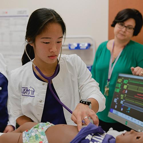 student using stethescope on dummy